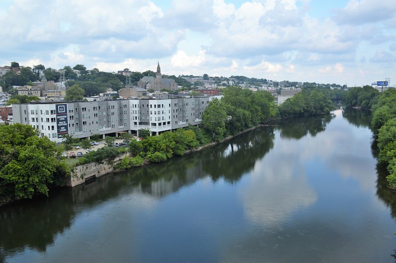 a river with a white building and city skyline beyond