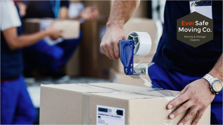 Professional mover taping a cardboard box as part of packing and moving services.